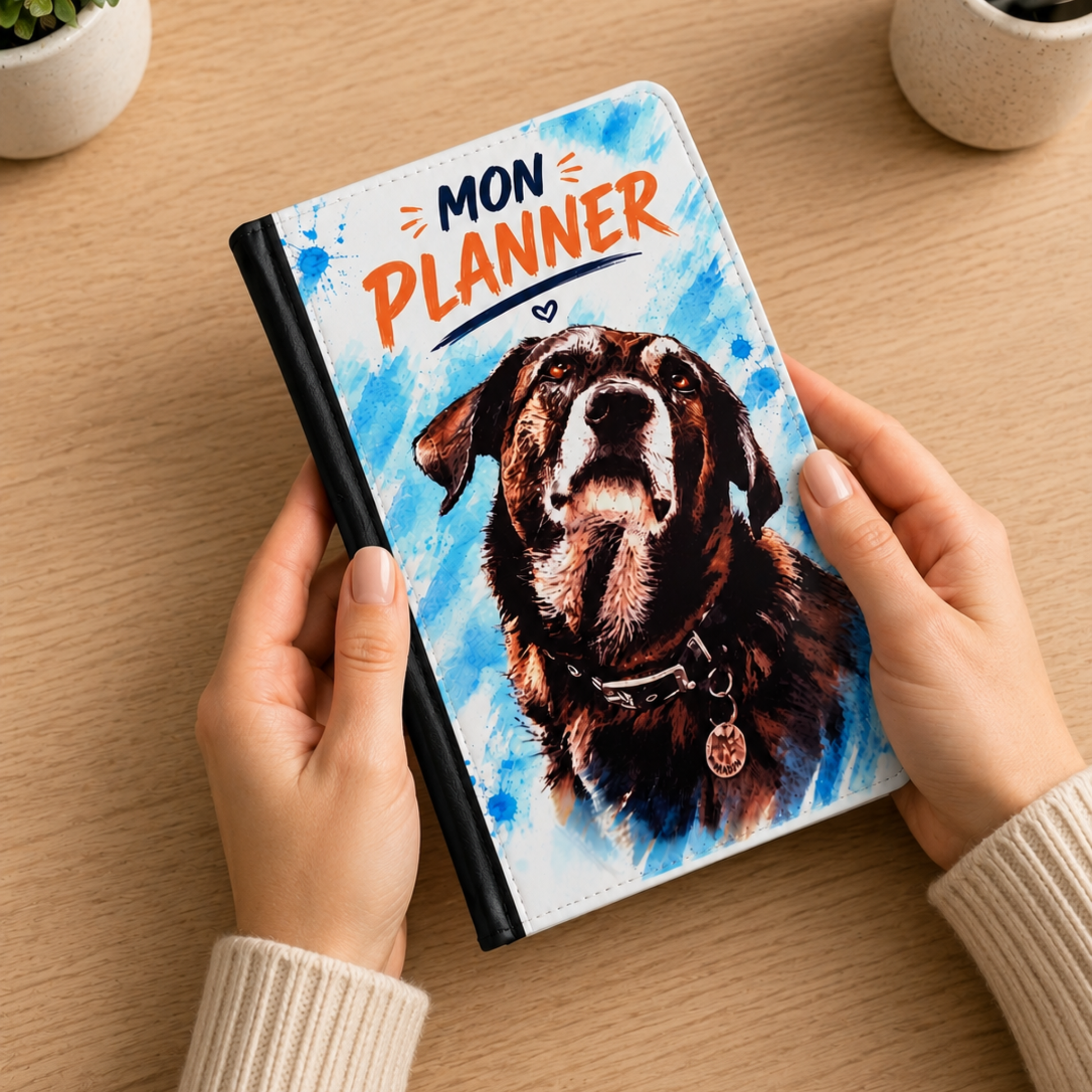 Planner personnalisé avec illustration aquarelle d'un chien, agenda rechargeable avec fermeture zippée tenu dans les mains.