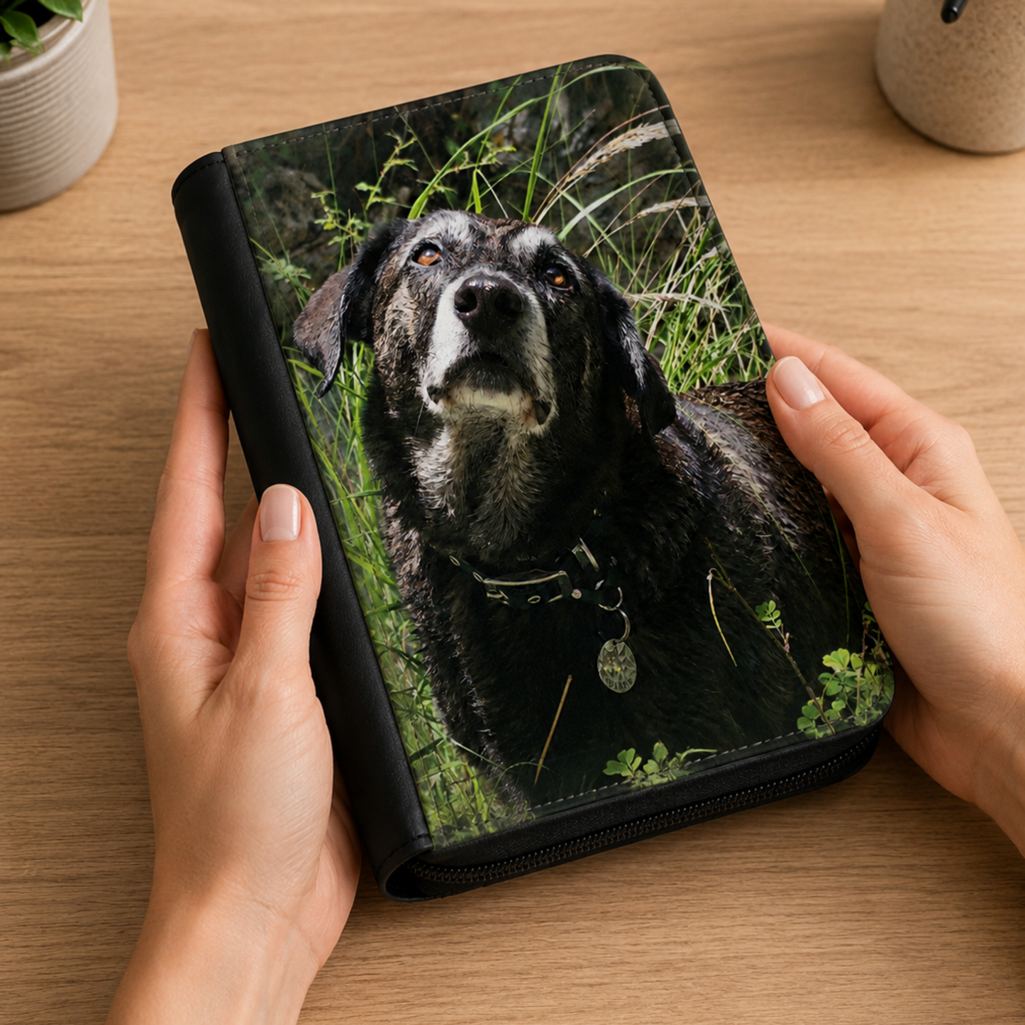 Planner personnalisé avec la photo réaliste d'un chien imprimée sur la couverture, tenu dans les mains, agenda rechargeable à fermeture zippée.